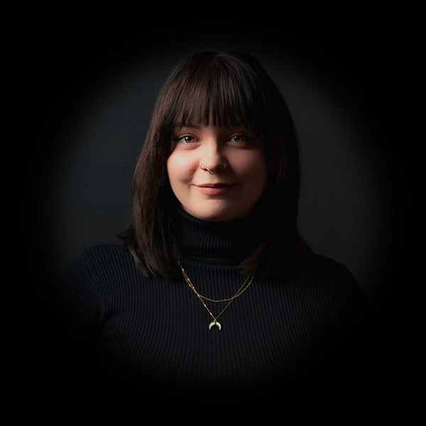 Portraitfoto von Bianca Hickisch mit dunklem Hintergrund.