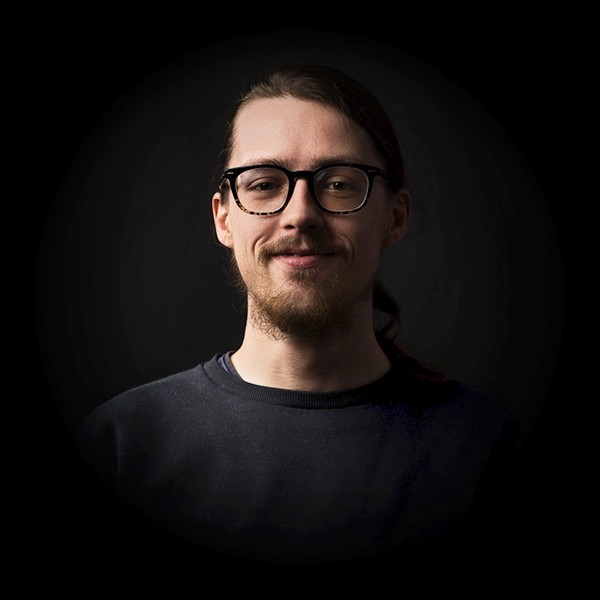 Portraitfoto von Christoph Kern mit dunklem Hintergrund.
