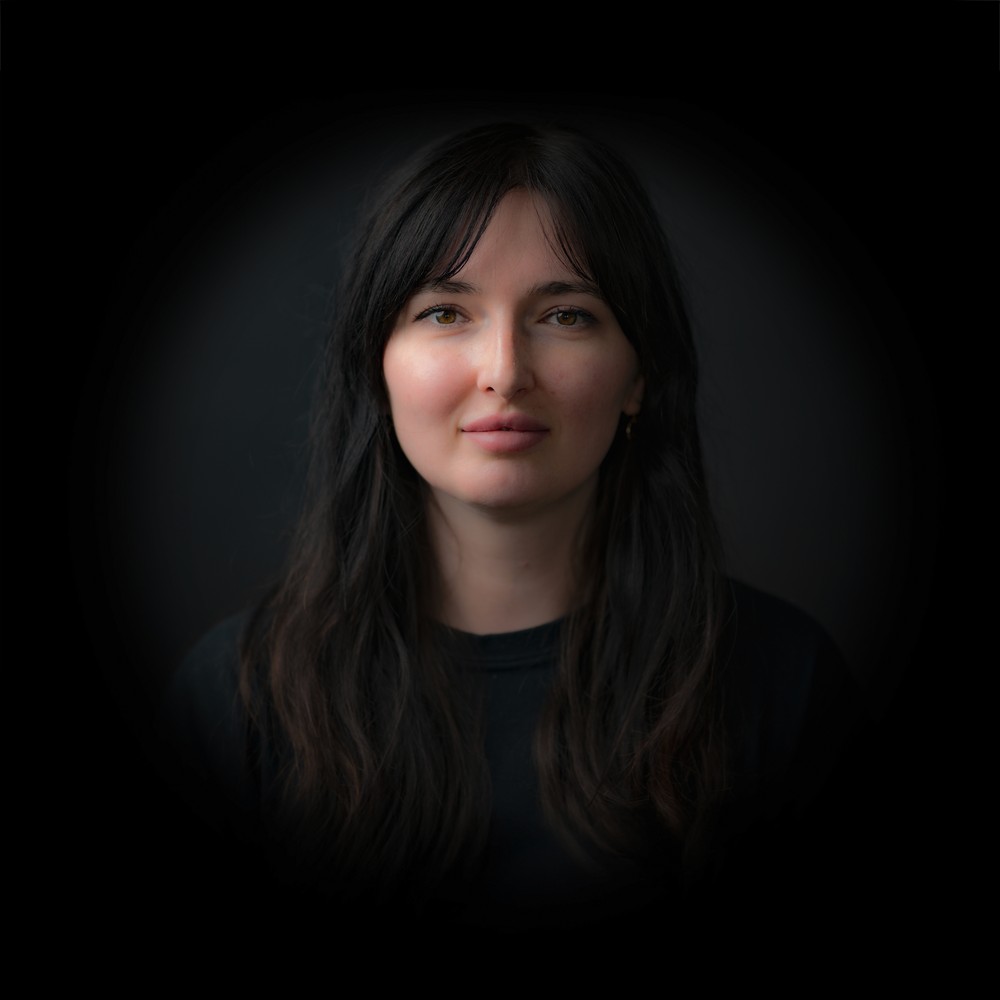 Portraitfoto von Daria Bilichuk mit dunklem Hintergrund.